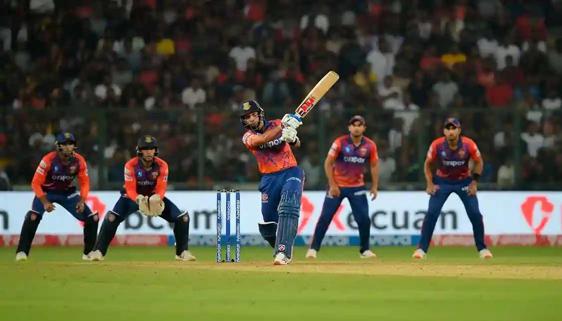 T20 cricketwedstrijd met batsman en fielders in actie onder stadionverlichting